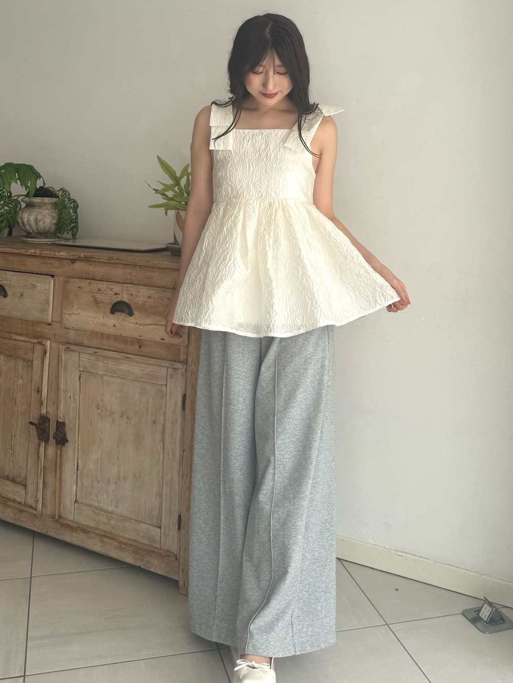 グレー系のその他パンツ、ホワイト系のシャツ/ブラウス、ホワイト系のパンプスを着用したレディースの夏コーディネートの3枚目の写真