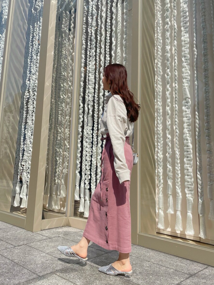 シルバー系のサンダル、ベージュ系のTシャツ/カットソー、ピンク系のスカートを着用したレディースの春コーディネートの2枚目の写真