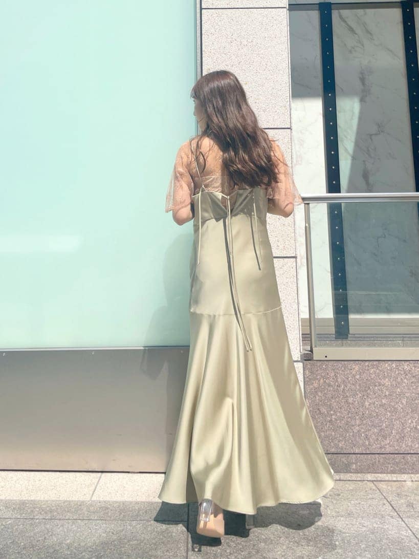 グリーン系のドレス、ベージュ系のパンプスを着用したレディースの夏コーディネートの2枚目の写真