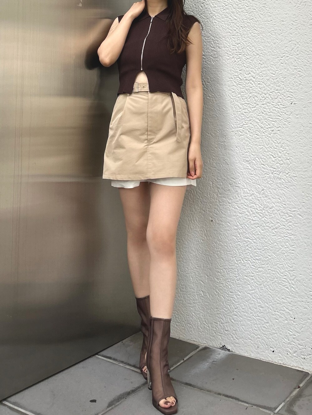 ブラウン系のニット/セーター、ベージュ系のスカートを着用したレディースの春コーディネートの2枚目の写真