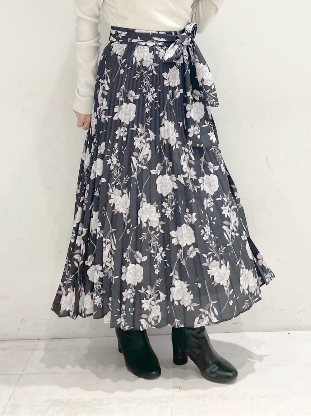 ホワイト系のニット/セーター、ブラック系のスカートを着用したレディースの冬コーディネートの4枚目の写真