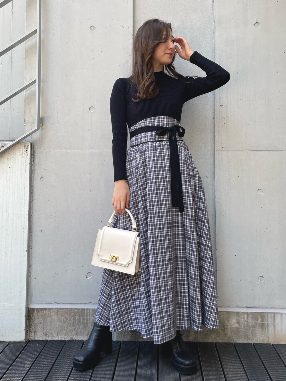 ブラック系のブーツ、ブラック系のワンピース、ブラック系のダウンジャケット/コートを着用したレディースの冬コーディネートの4枚目の写真