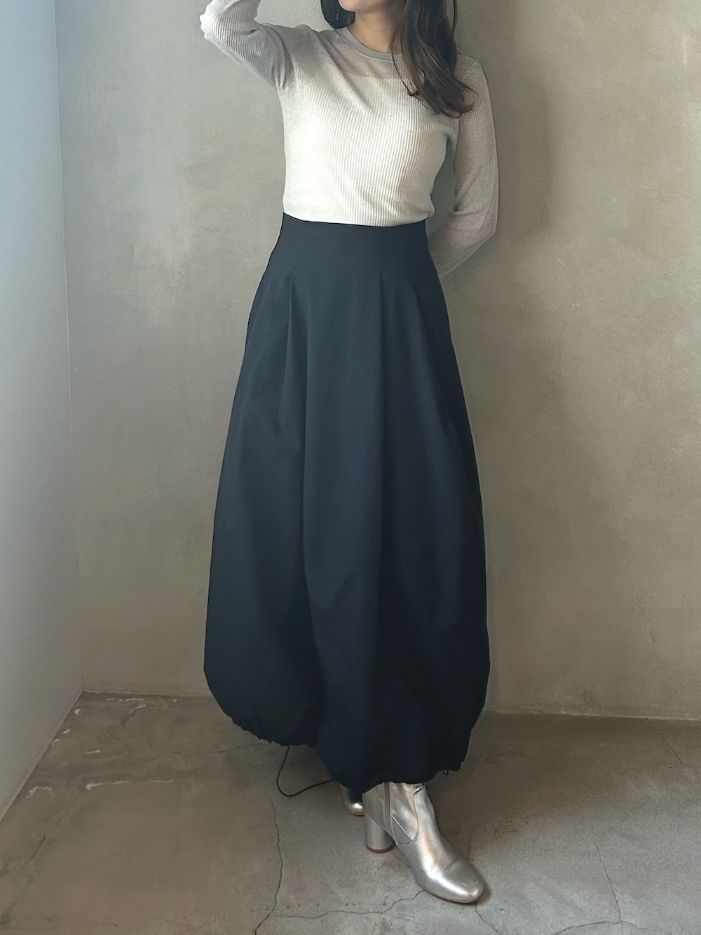 グレー系のニット/セーター、ホワイト系のMA-1、ブラック系のスカートを着用したレディースの春コーディネートの5枚目の写真