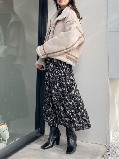 ベージュ系のムートンコート、ベージュ系のムートンコート、ブラック系のワンピースを着用したレディースの秋コーディネートの2枚目の写真