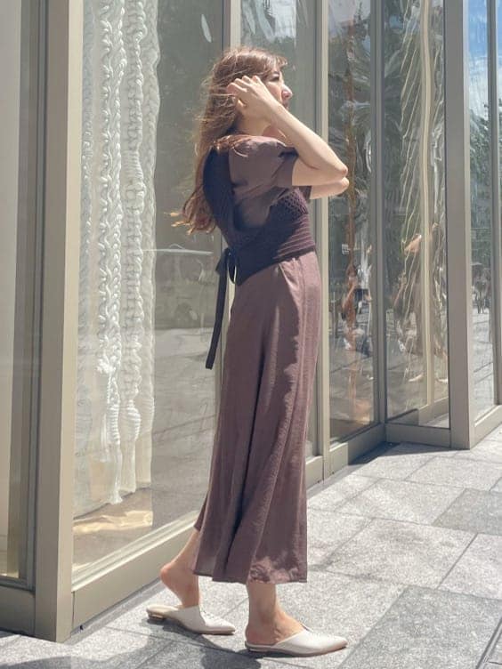 ブラウン系のワンピース、ホワイト系のサンダル、ブラウン系のニット/セーターを着用したレディースの秋コーディネートの2枚目の写真