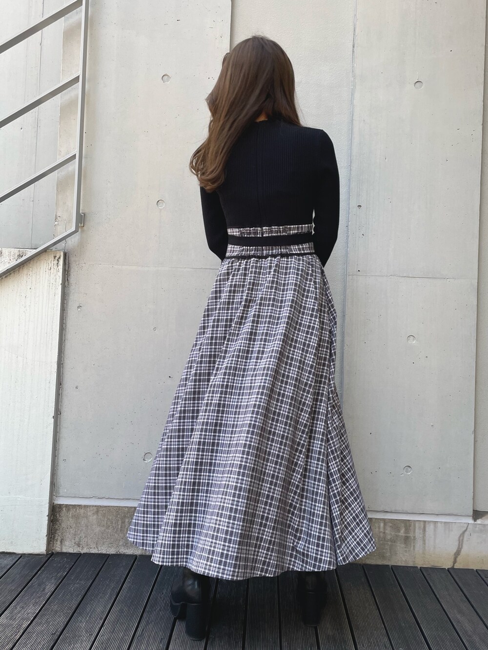 ブラック系のブーツ、ブラック系のワンピース、ブラック系のダウンジャケット/コートを着用したレディースの冬コーディネートの6枚目の写真