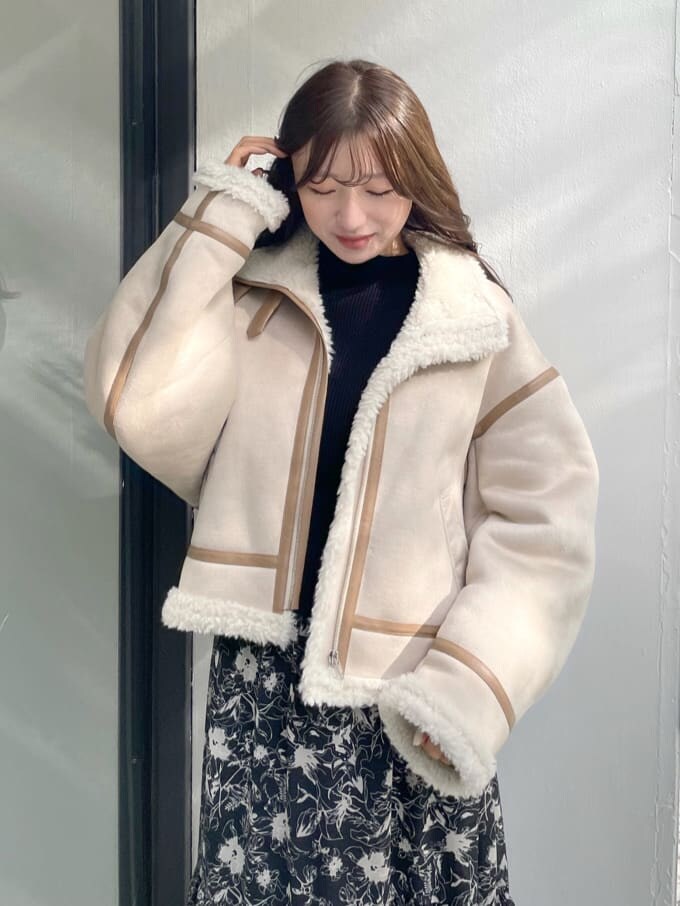 ベージュ系のムートンコート、ベージュ系のムートンコート、ブラック系のワンピースを着用したレディースの秋コーディネートの5枚目の写真