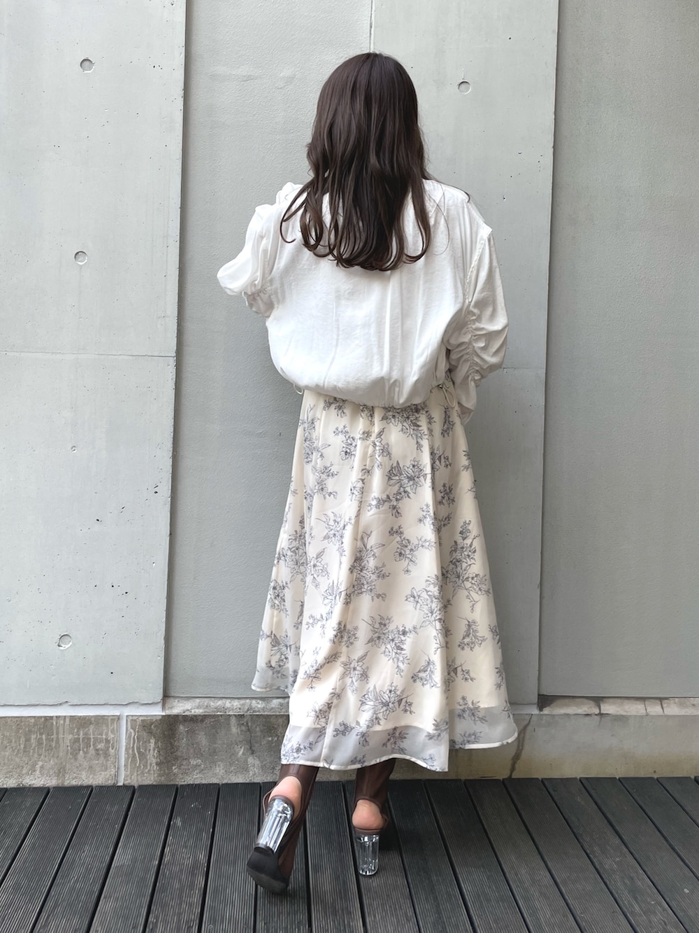 ブラック系のブーツ、ブラック系のハンドバッグ、ホワイト系のワンピースを着用したレディースの春コーディネートの5枚目の写真