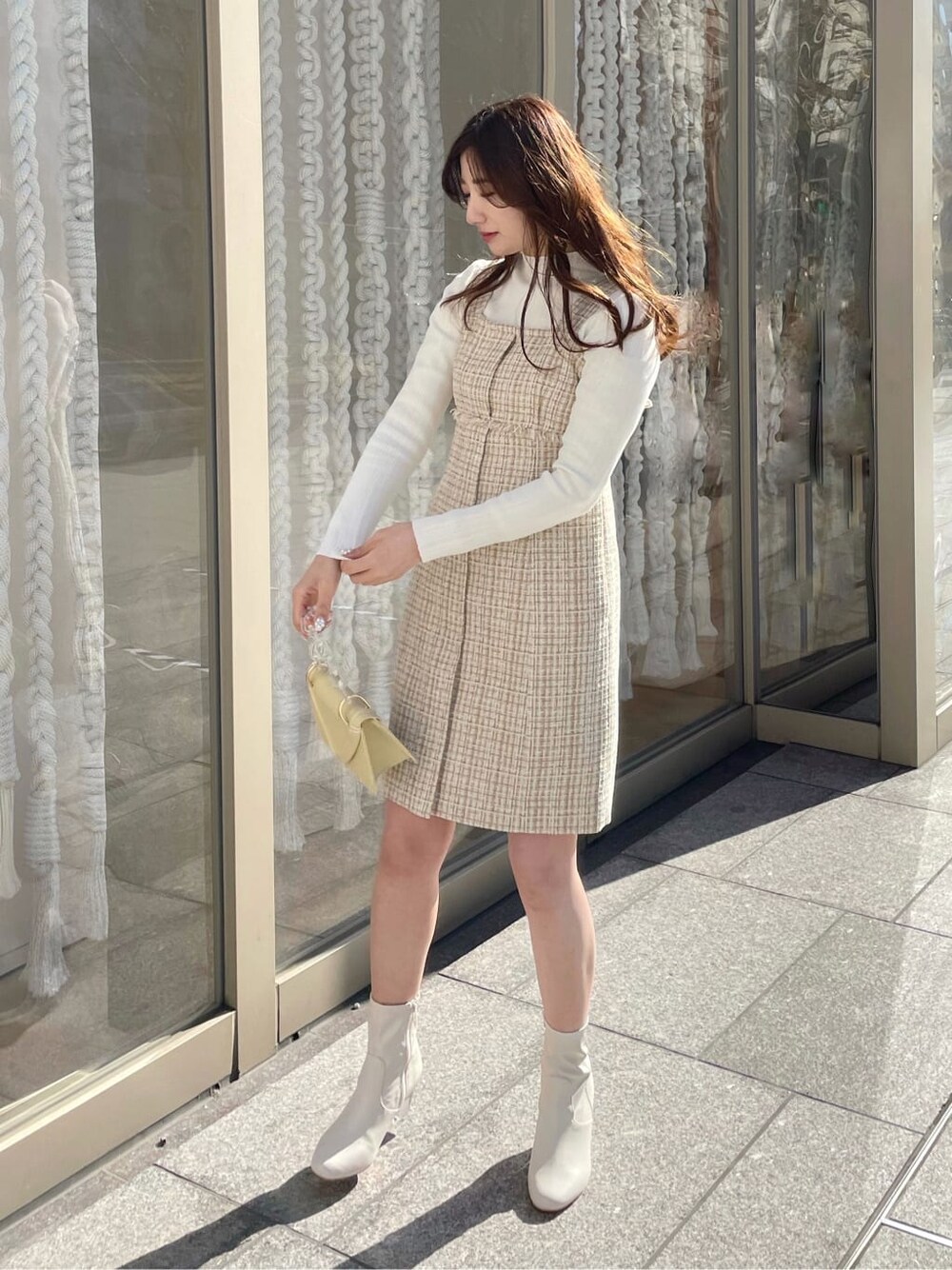 ホワイト系のニット/セーター、イエロー系のテーラードジャケット、イエロー系のワンピースを着用したレディースの冬コーディネートの5枚目の写真