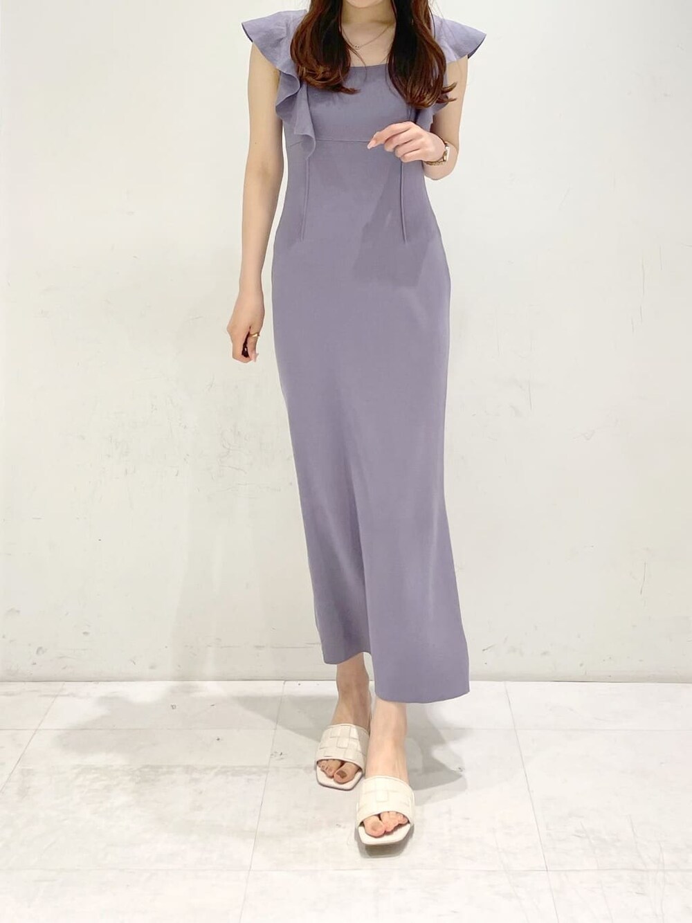 ホワイト系のサンダル、パープル系のワンピースを着用したレディースの春コーディネートの3枚目の写真