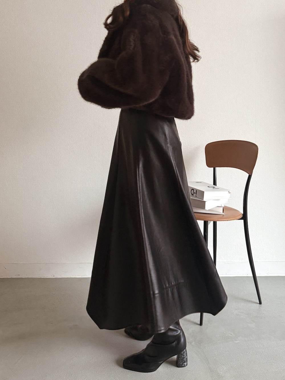 ブルー系のニット/セーター、ブラウン系のその他アウター、ブラック系のスカートを着用したレディースの秋コーディネートの4枚目の写真