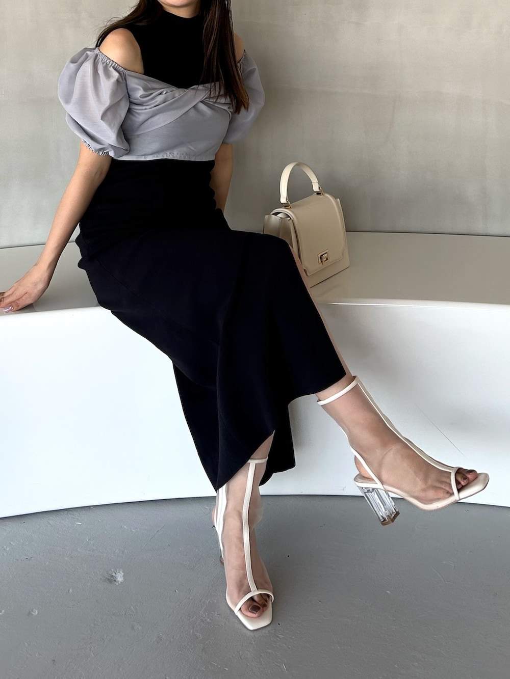 ブルー系のワンピース、ホワイト系のハンドバッグ、ホワイト系のブーツを着用したレディースの冬コーディネートの2枚目の写真