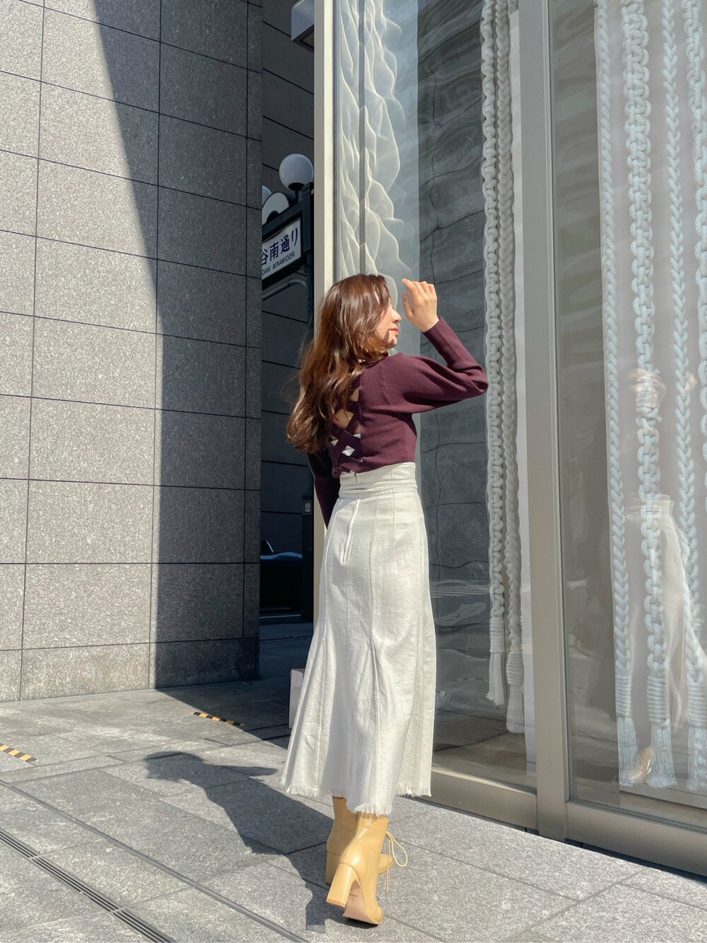 ホワイト系のスカート、ブラウン系のニット/セーターを着用したレディースの春コーディネートの3枚目の写真