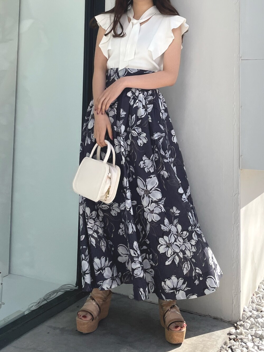 ホワイト系のニット/セーター、パープル系のスカート、ブラック系のハンドバッグを着用したレディースの春コーディネートの3枚目の写真