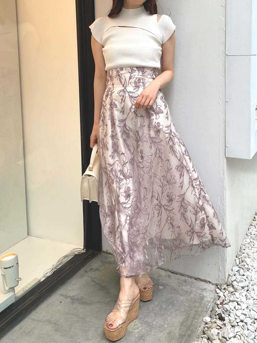 ホワイト系のニット/セーター、ピンク系のスカート、ホワイト系のサンダルを着用したレディースの春コーディネートの2枚目の写真