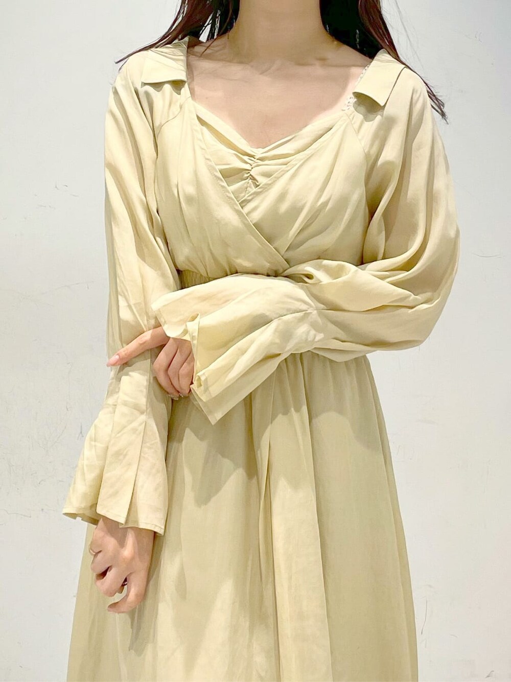 イエロー系のワンピース、ブラウン系のパンプスを着用したレディースの冬コーディネートの4枚目の写真