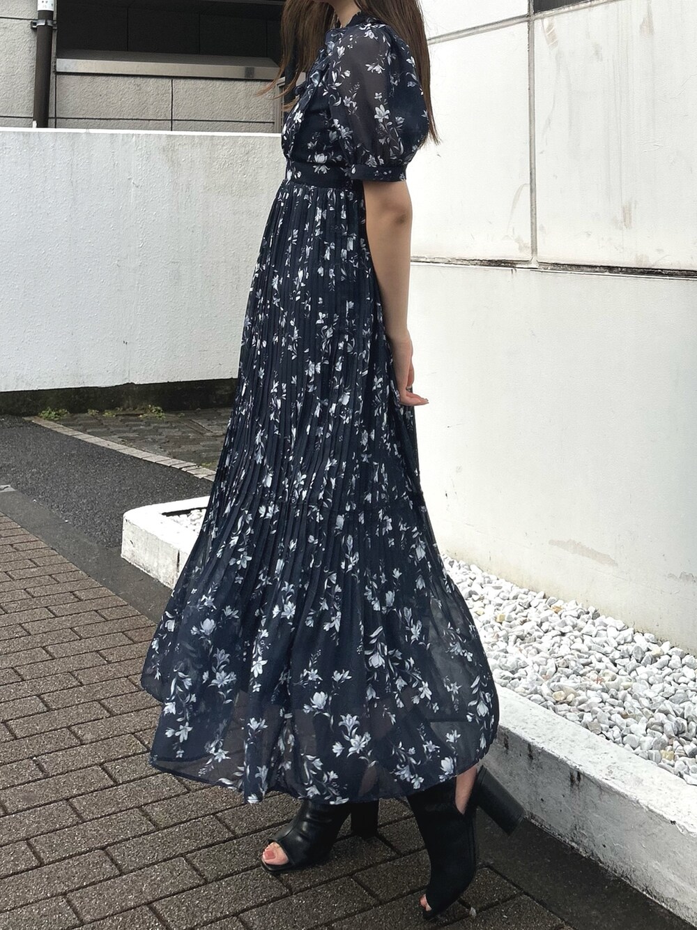 ブルー系のワンピース、ブラック系のブーツ、ブラック系のハンドバッグを着用したレディースの春コーディネートの3枚目の写真