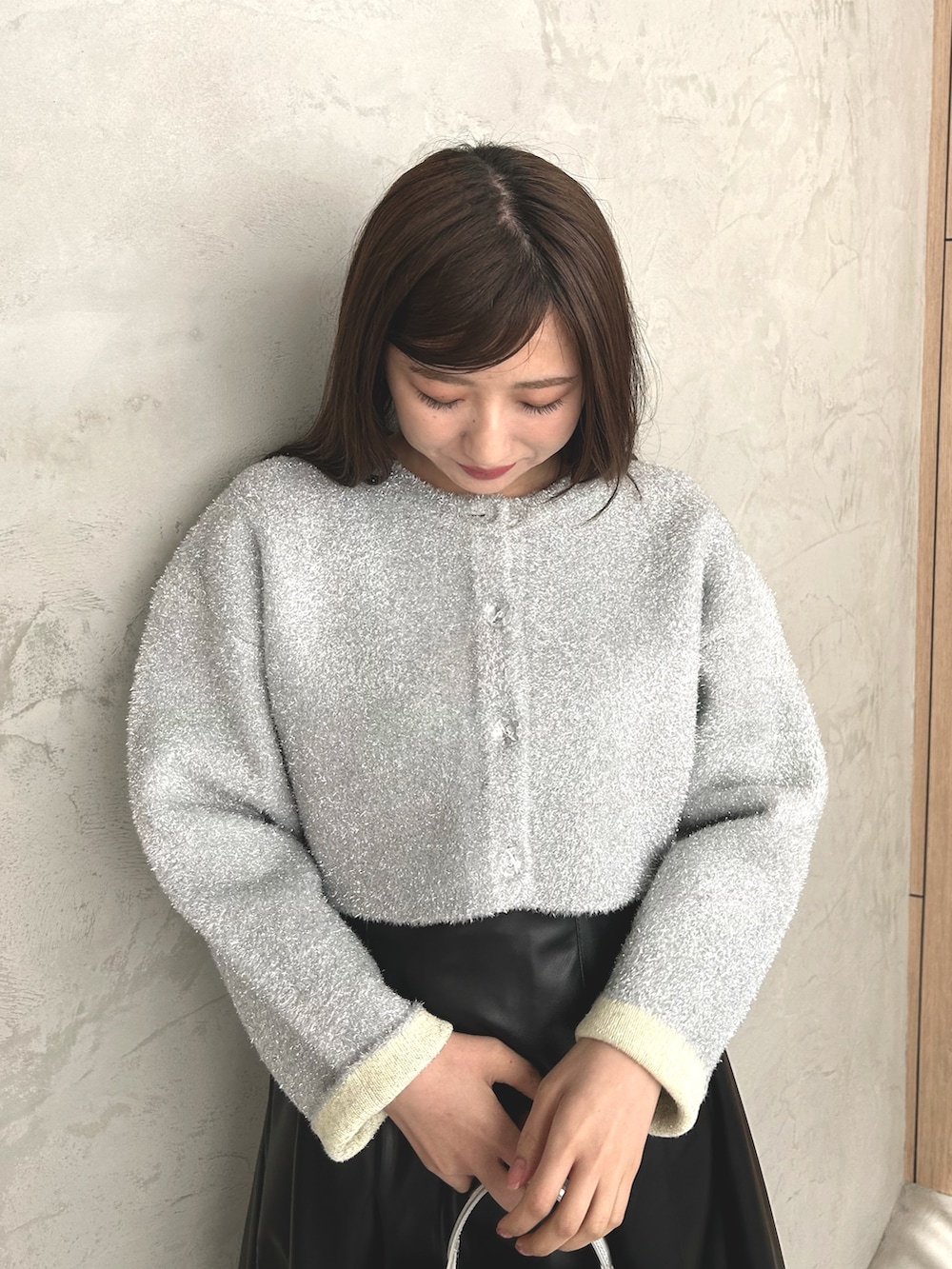 シルバー系のカーディガン/ボレロ、ブラック系のスカート、ブラック系のローファーを着用したレディースの冬コーディネートの3枚目の写真