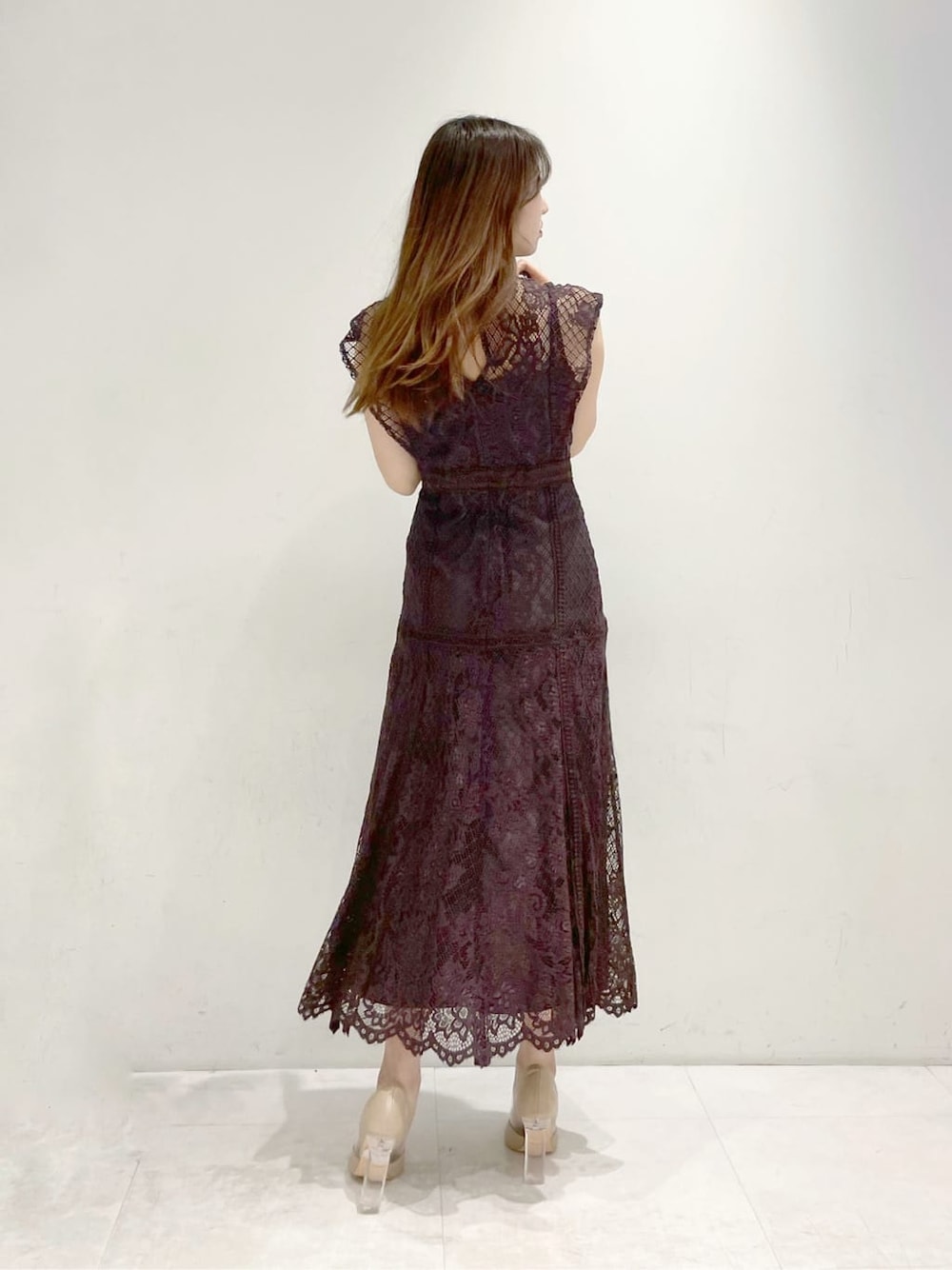 ベージュ系のパンプス、ブラウン系のドレスを着用したレディースの冬コーディネートの2枚目の写真