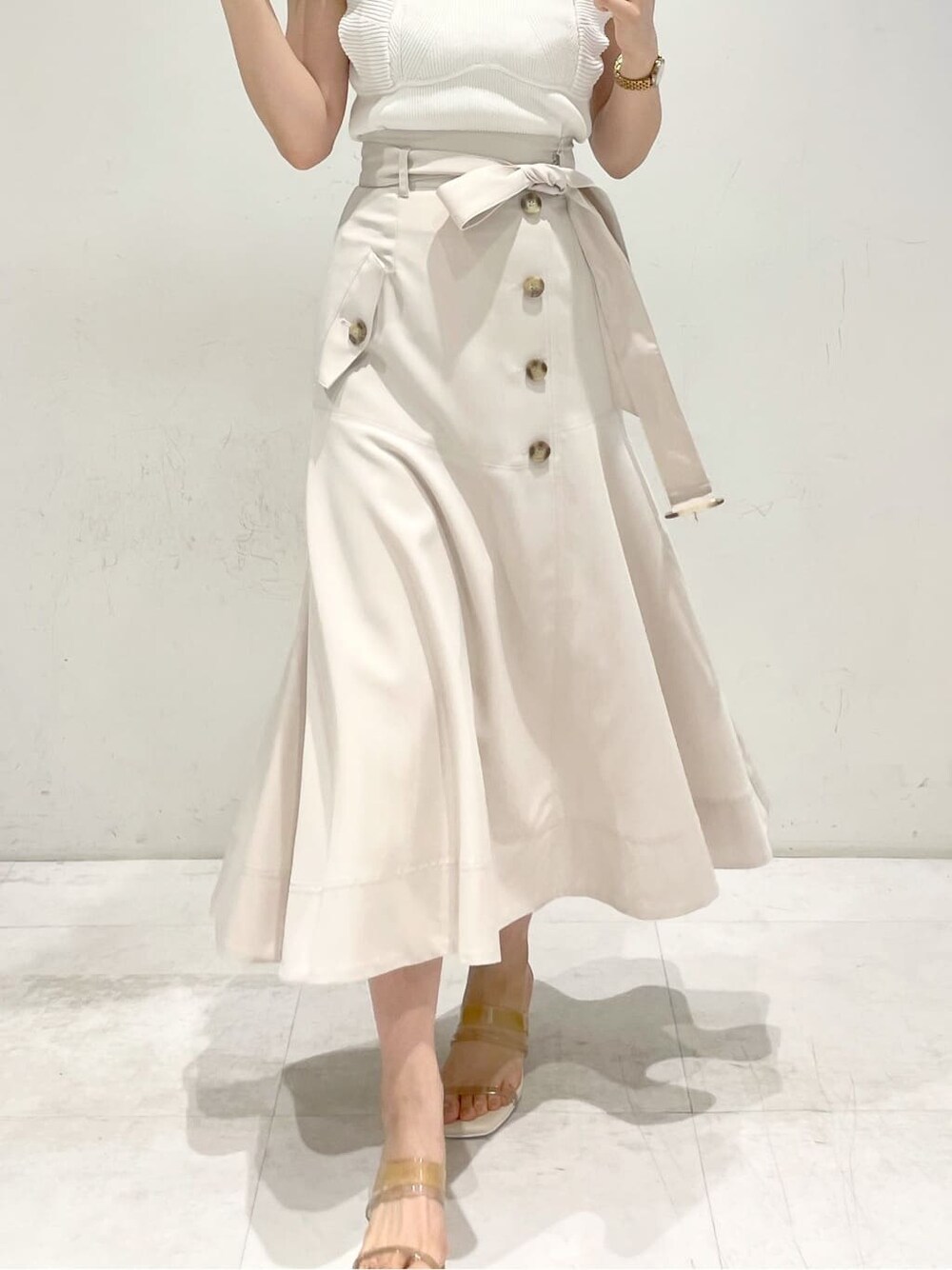 ベージュ系のサンダル、ホワイト系のニット/セーター、ホワイト系のスカートを着用したレディースの春コーディネートの6枚目の写真