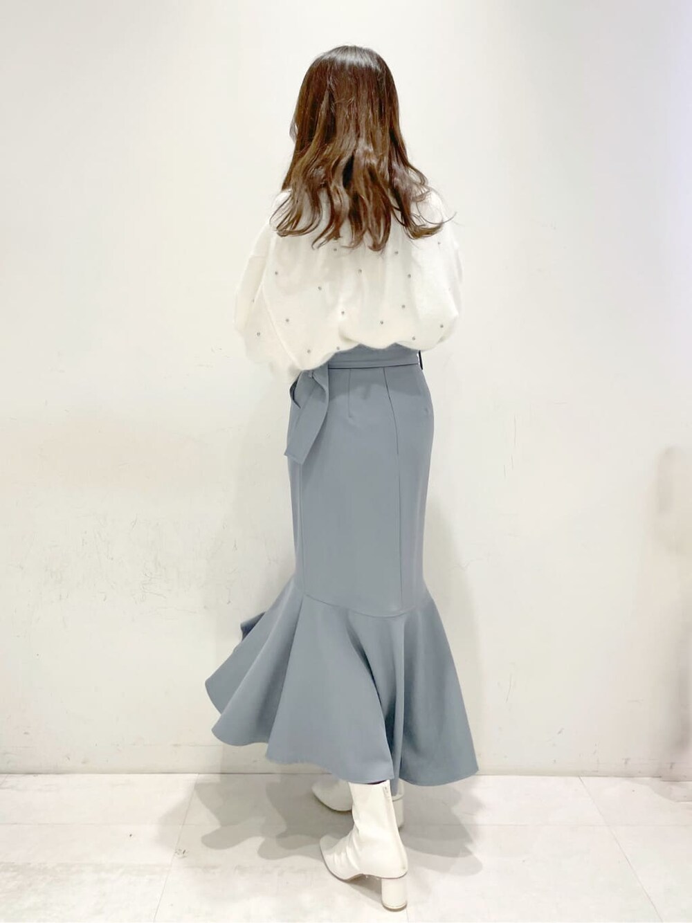 ホワイト系のその他シューズ、ブルー系のスカート、ホワイト系のカーディガン/ボレロを着用したレディースの冬コーディネートの3枚目の写真