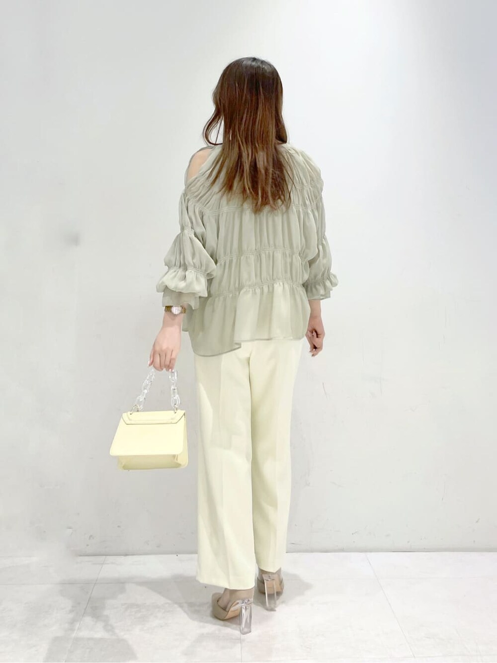 イエロー系のシャツ/ブラウス、ベージュ系のパンプス、イエロー系のショルダーバッグを着用したレディースの冬コーディネートの3枚目の写真