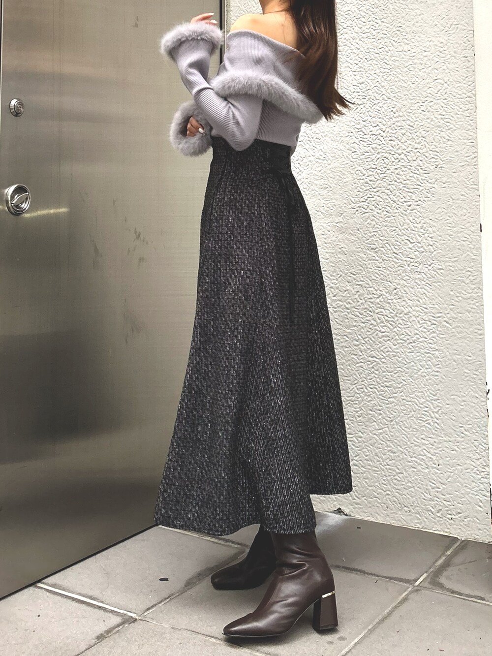 グレー系のニット/セーター、ブラック系のスカート、ブラウン系のブーツを着用したレディースの冬コーディネートの3枚目の写真