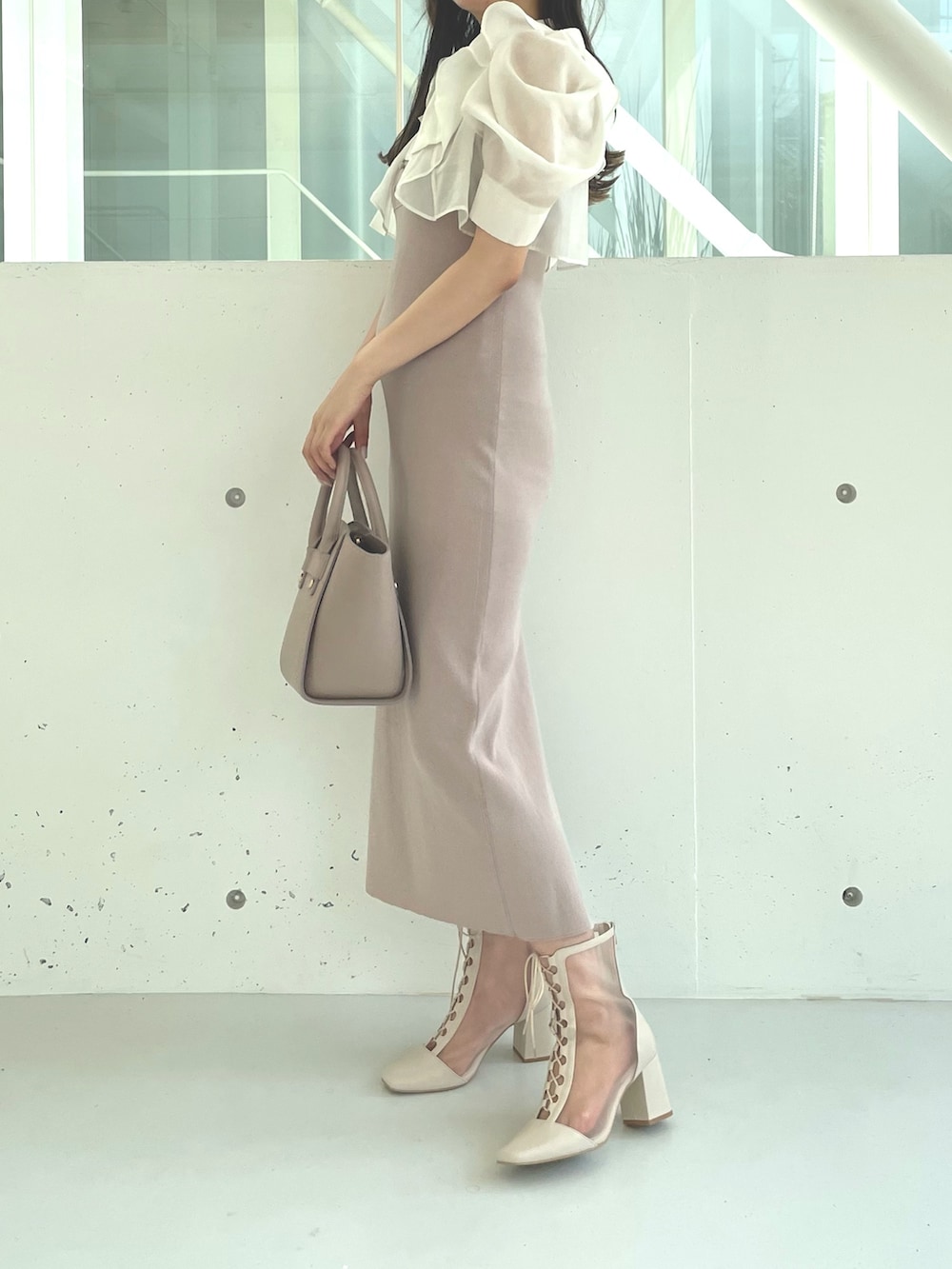 ホワイト系のブーツ、ベージュ系のワンピース、ベージュ系のハンドバッグを着用したレディースの夏コーディネートの3枚目の写真