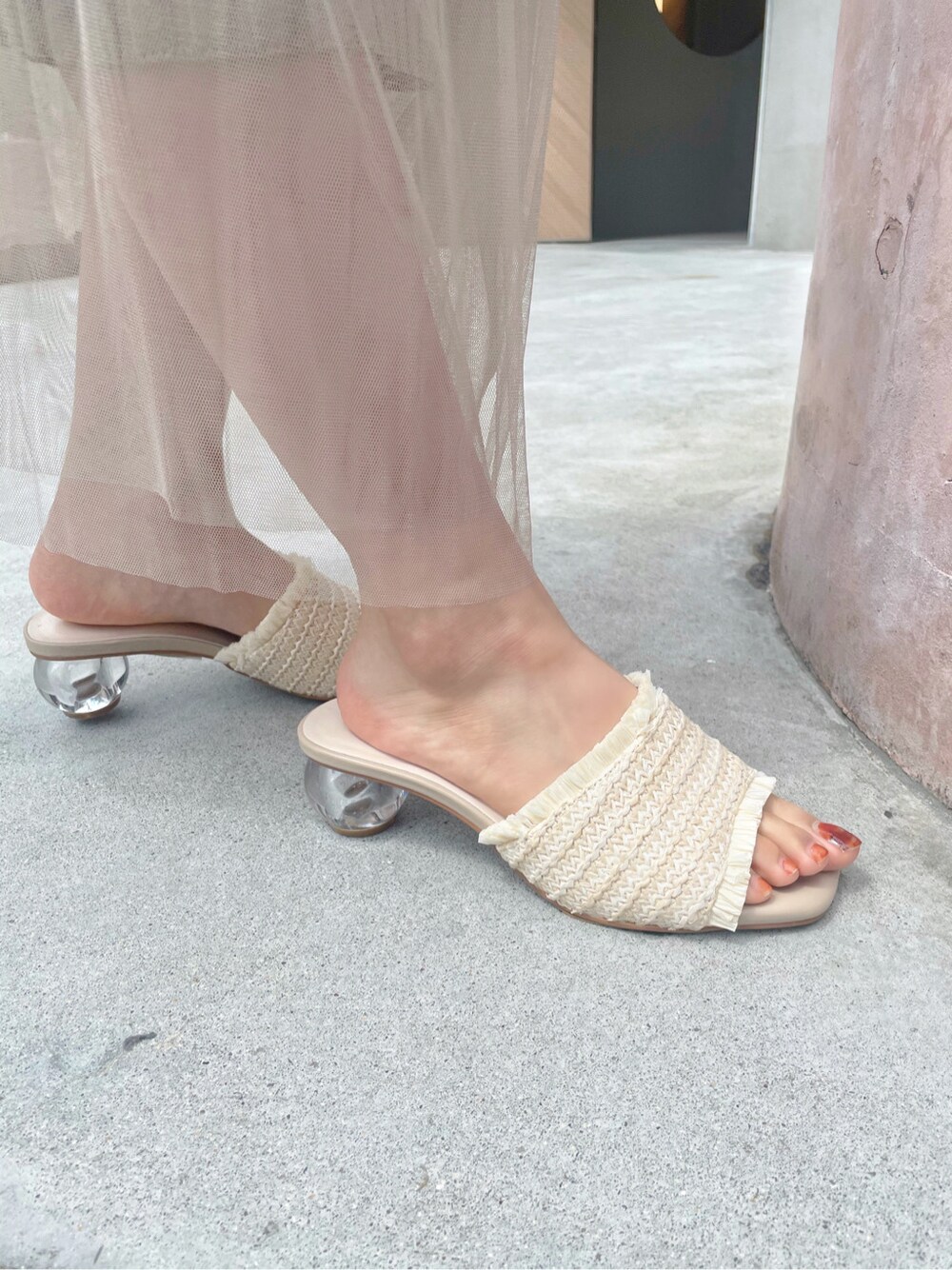 ベージュ系のワンピース、ホワイト系のサンダル、ゴールド系のイヤリングを着用したレディースの春コーディネートの6枚目の写真