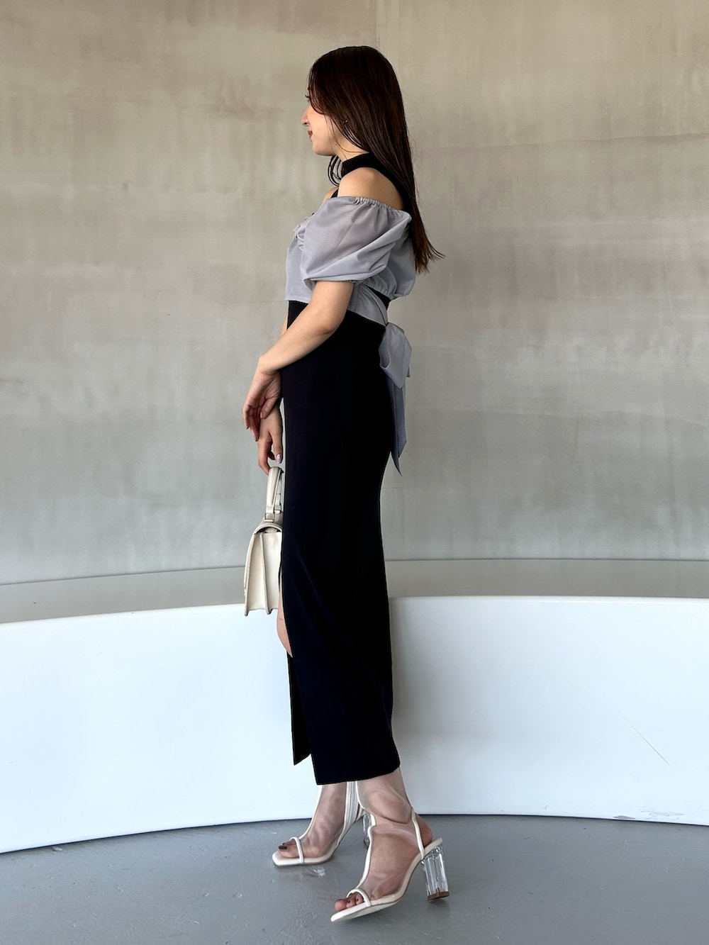 ブルー系のワンピース、ホワイト系のハンドバッグ、ホワイト系のブーツを着用したレディースの冬コーディネートの3枚目の写真