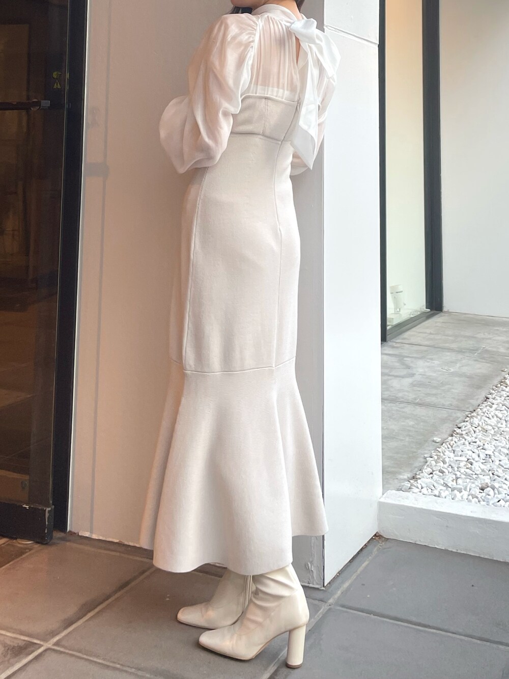 ホワイト系のワンピース、ベージュ系のライダースジャケットを着用したレディースの冬コーディネートの5枚目の写真