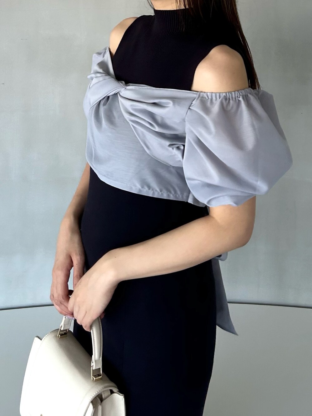 ブルー系のワンピース、ホワイト系のハンドバッグ、ホワイト系のブーツを着用したレディースの冬コーディネートの5枚目の写真