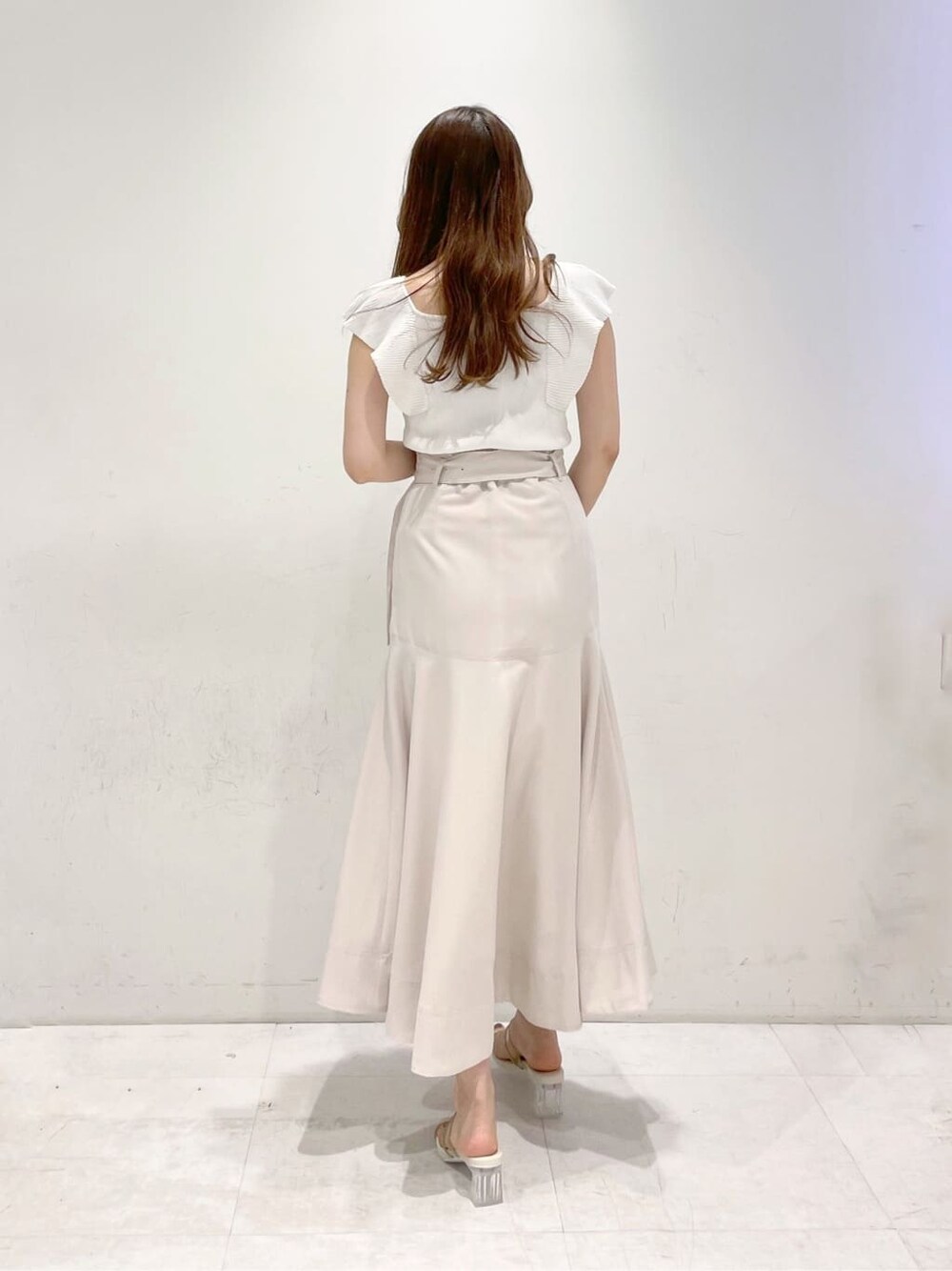 ベージュ系のサンダル、ホワイト系のニット/セーター、ホワイト系のスカートを着用したレディースの春コーディネートの3枚目の写真