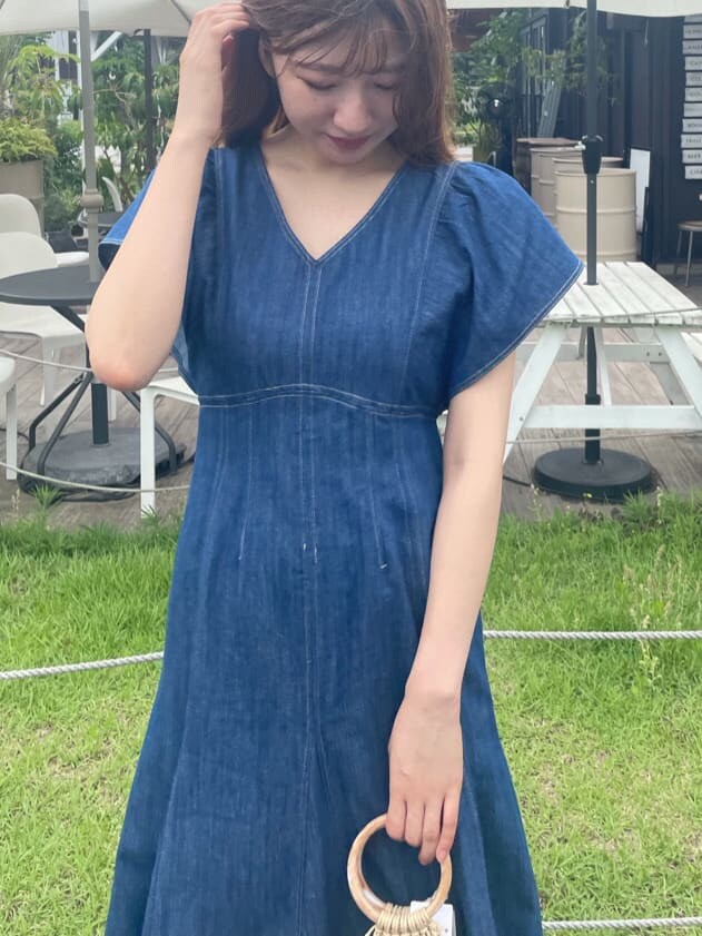 ホワイト系のハンドバッグ、ホワイト系のサンダル、ブルー系のワンピースを着用したレディースの夏コーディネートの4枚目の写真