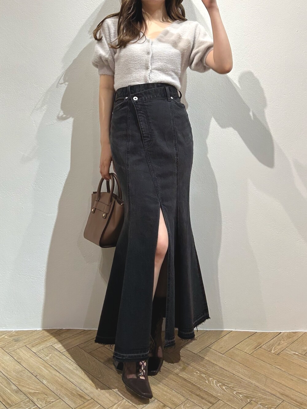 グレー系のカーディガン/ボレロ、ブラック系のスカート、ブラウン系のブーツを着用したレディースの夏コーディネートの2枚目の写真