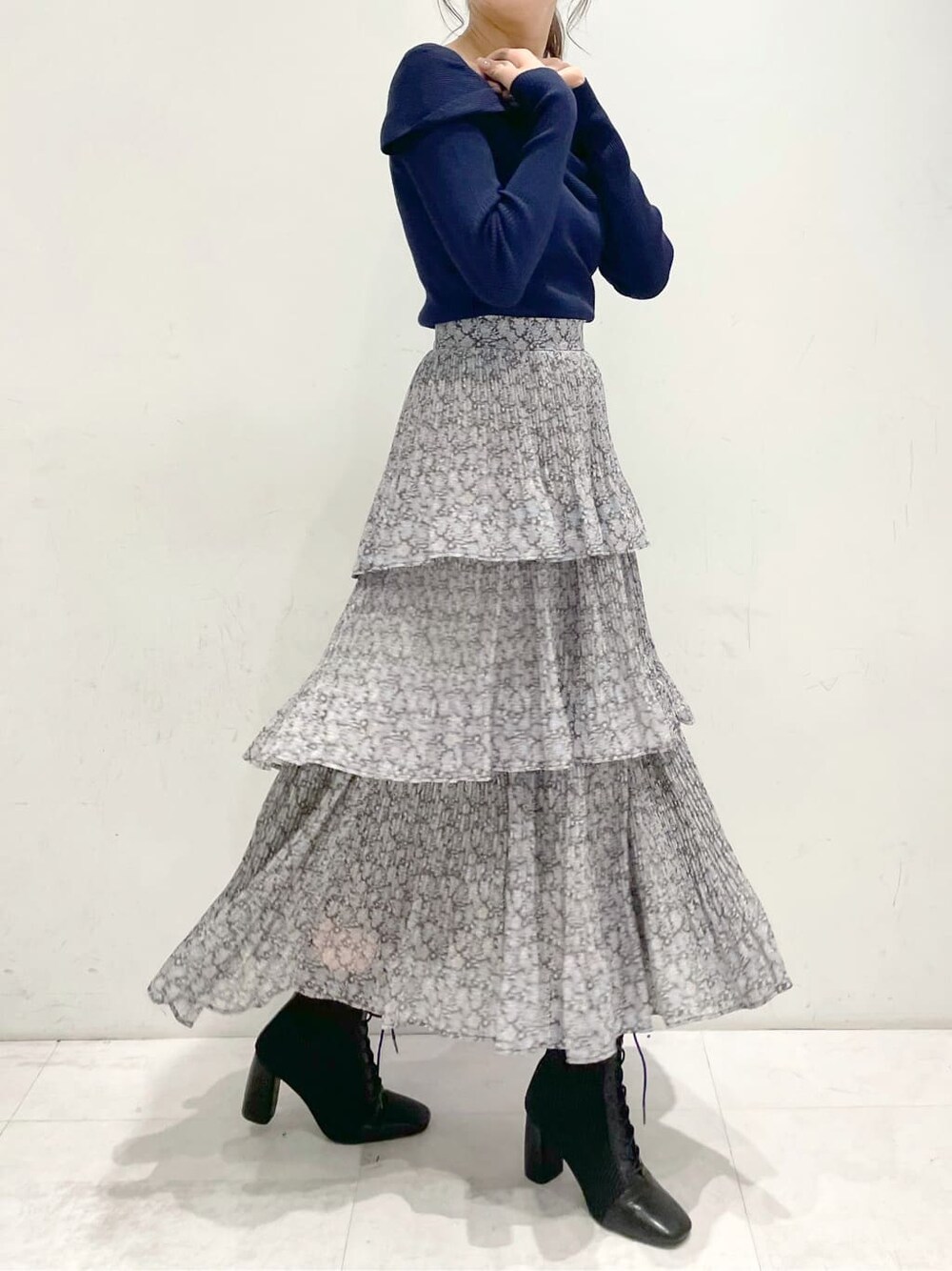 ブラック系のブーツ、ブルー系のスカート、ブルー系のニット/セーターを着用したレディースの冬コーディネートの4枚目の写真