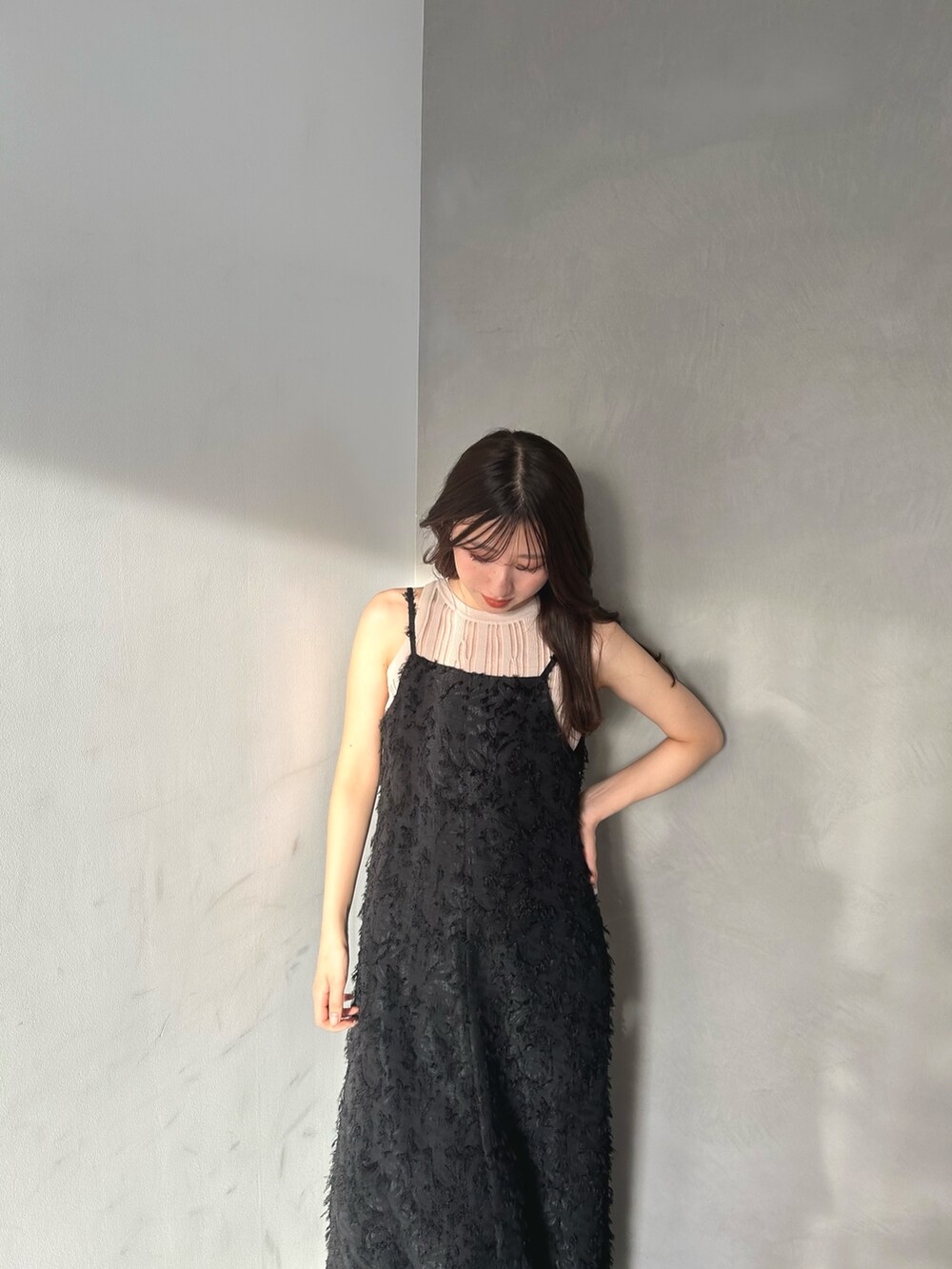 ベージュ系のニット/セーター、ブラック系のワンピースを着用したレディースの春コーディネートの3枚目の写真