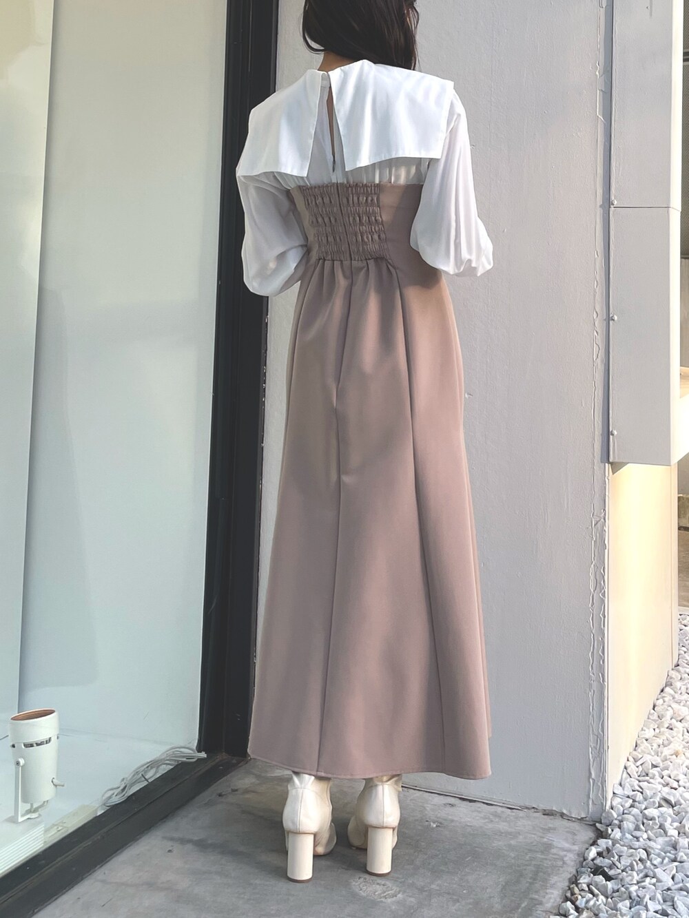 ベージュ系のワンピース、ブラウン系のチェスターコートを着用したレディースの冬コーディネートの4枚目の写真