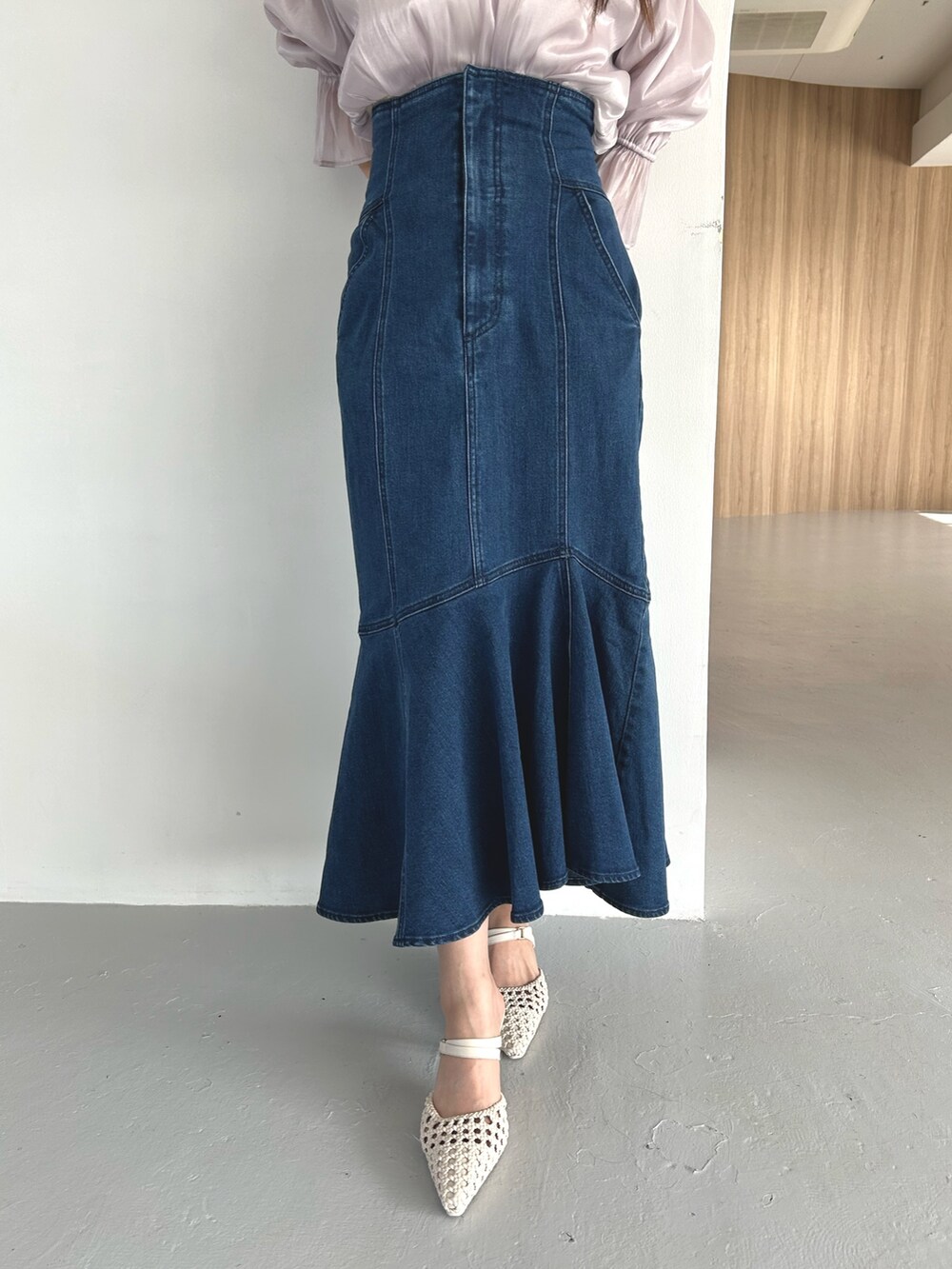 パープル系のシャツ/ブラウス、ブルー系のデニムスカート、ホワイト系のパンプスを着用したレディースの春コーディネートの8枚目の写真