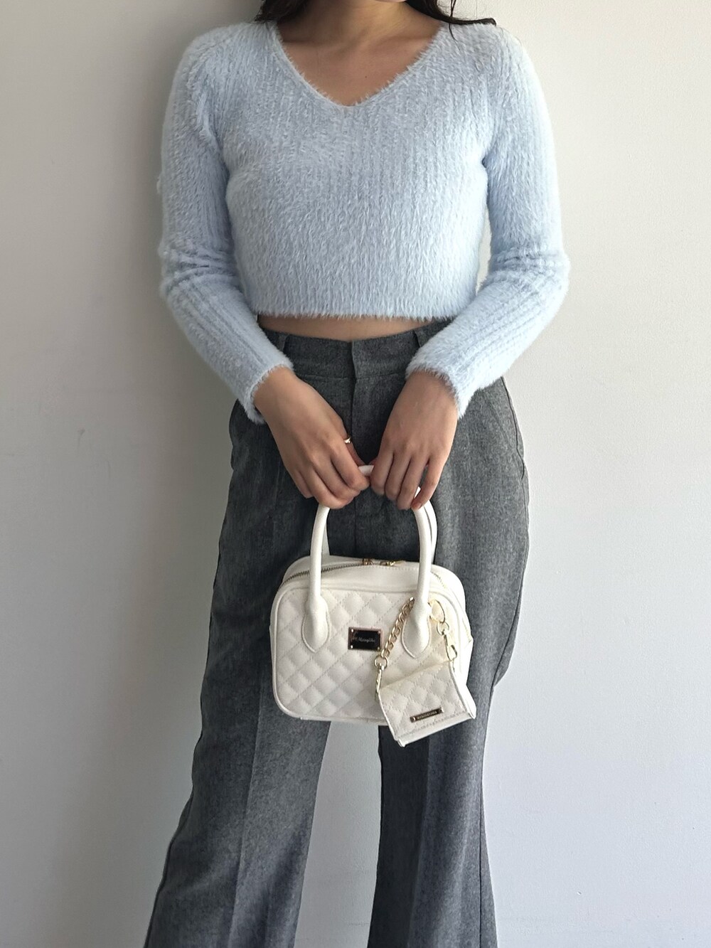 ブルー系のニット/セーター、グレー系のその他パンツ、ホワイト系のハンドバッグを着用したレディースの秋コーディネートの3枚目の写真