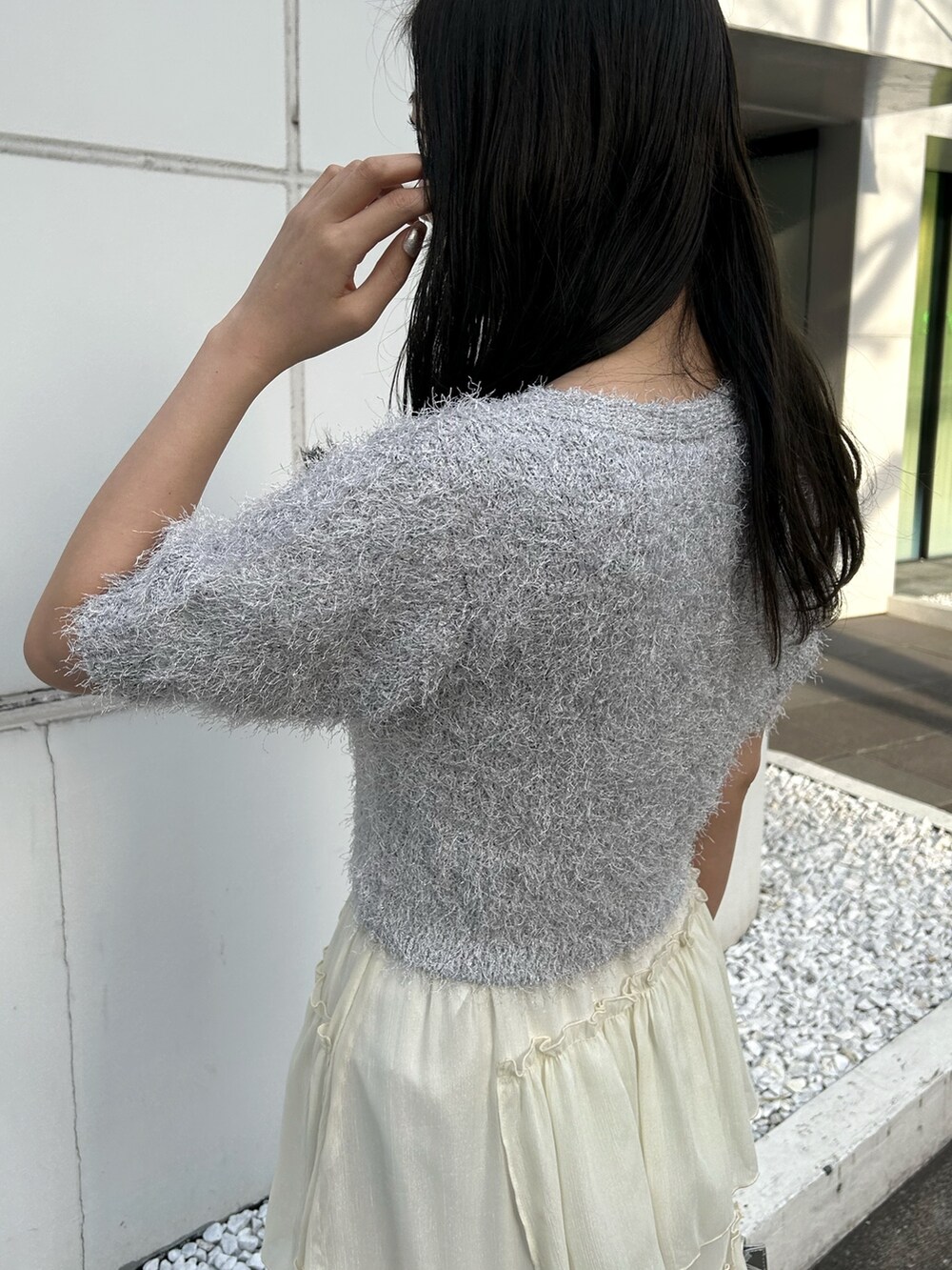 ホワイト系のカーディガン/ボレロ、シルバー系のハンドバッグ、ホワイト系のスカートを着用したレディースの冬コーディネートの4枚目の写真