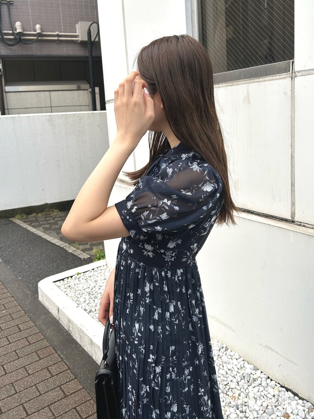 ブルー系のワンピース、ブラック系のブーツ、ブラック系のハンドバッグを着用したレディースの春コーディネートの6枚目の写真