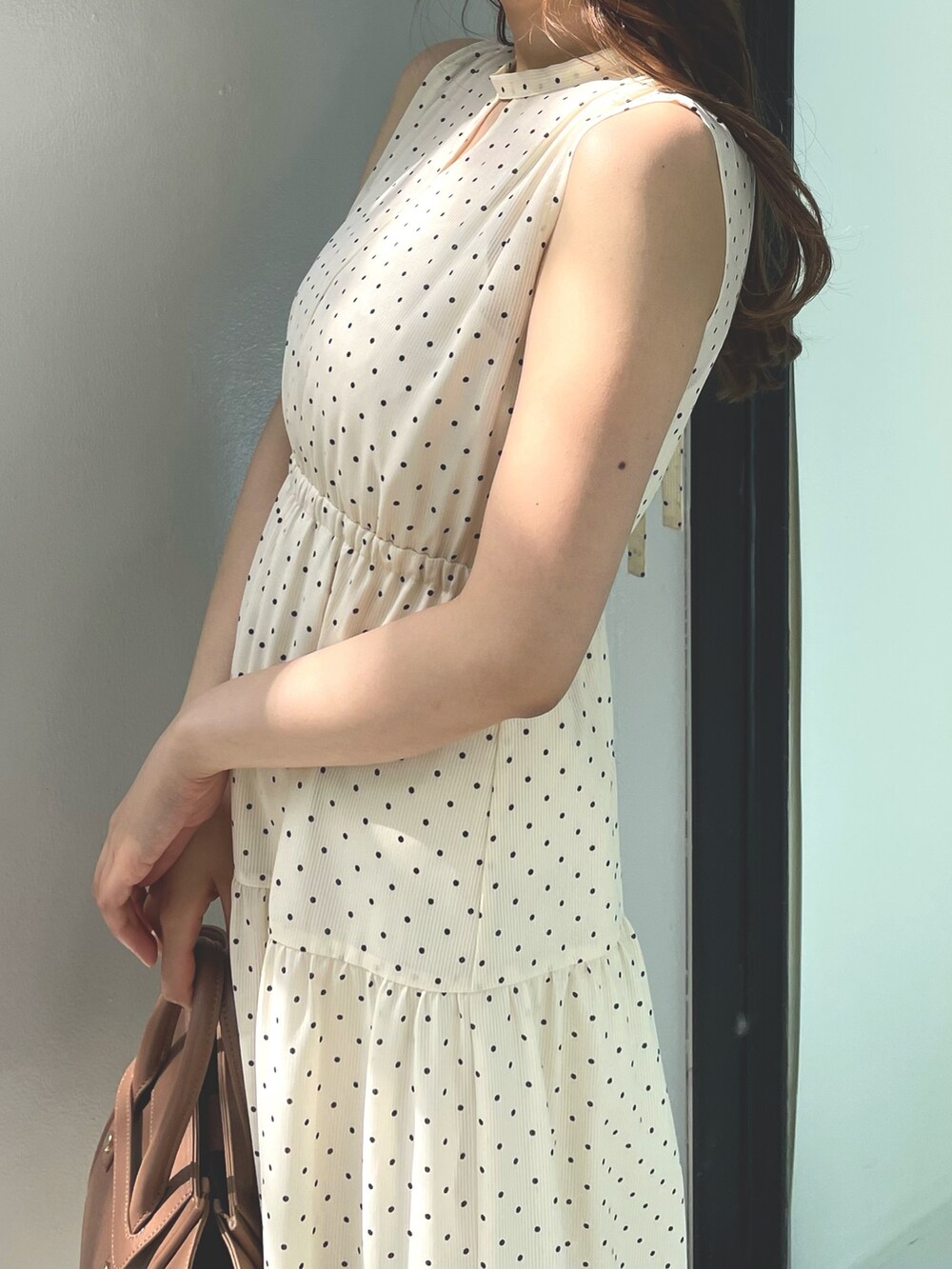 ベージュ系のワンピース、ブラウン系のトートバッグ、ホワイト系のサンダルを着用したレディースの夏コーディネートの7枚目の写真