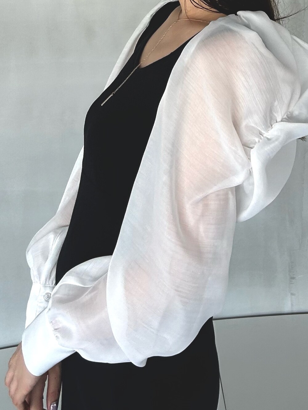 ブラック系のワンピース、ホワイト系のサンダルを着用したレディースの冬コーディネートの5枚目の写真