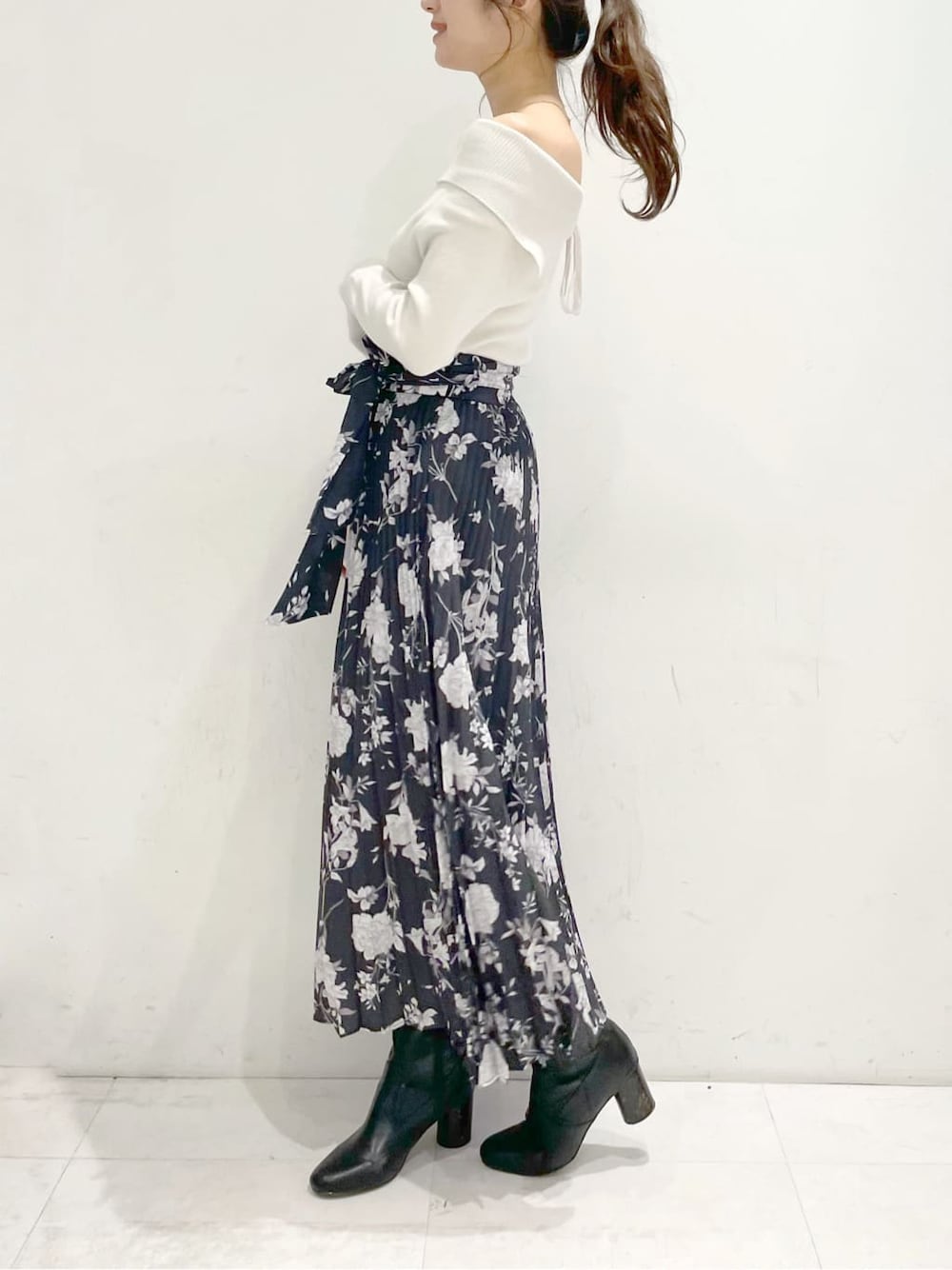 ホワイト系のニット/セーター、ブラック系のスカートを着用したレディースの冬コーディネートの2枚目の写真