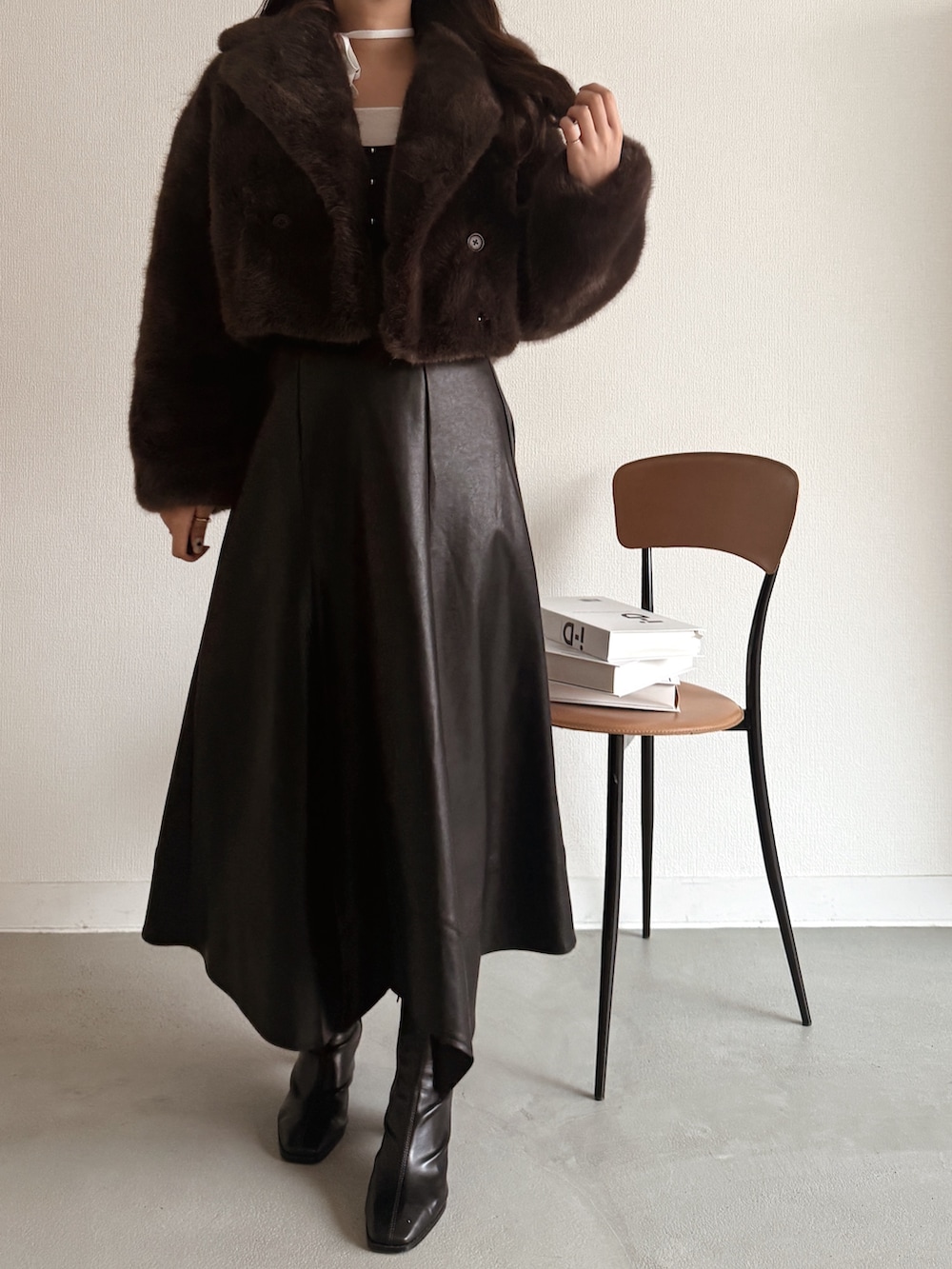 ブルー系のニット/セーター、ブラウン系のその他アウター、ブラック系のスカートを着用したレディースの秋コーディネートの5枚目の写真