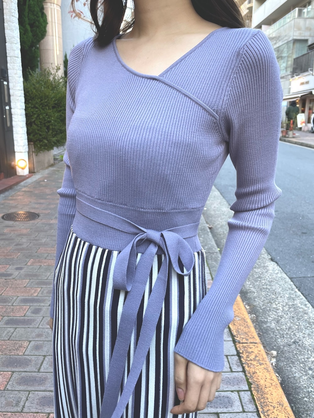 パープル系のワンピース、ホワイト系のライダースジャケットを着用したレディースの冬コーディネートの4枚目の写真