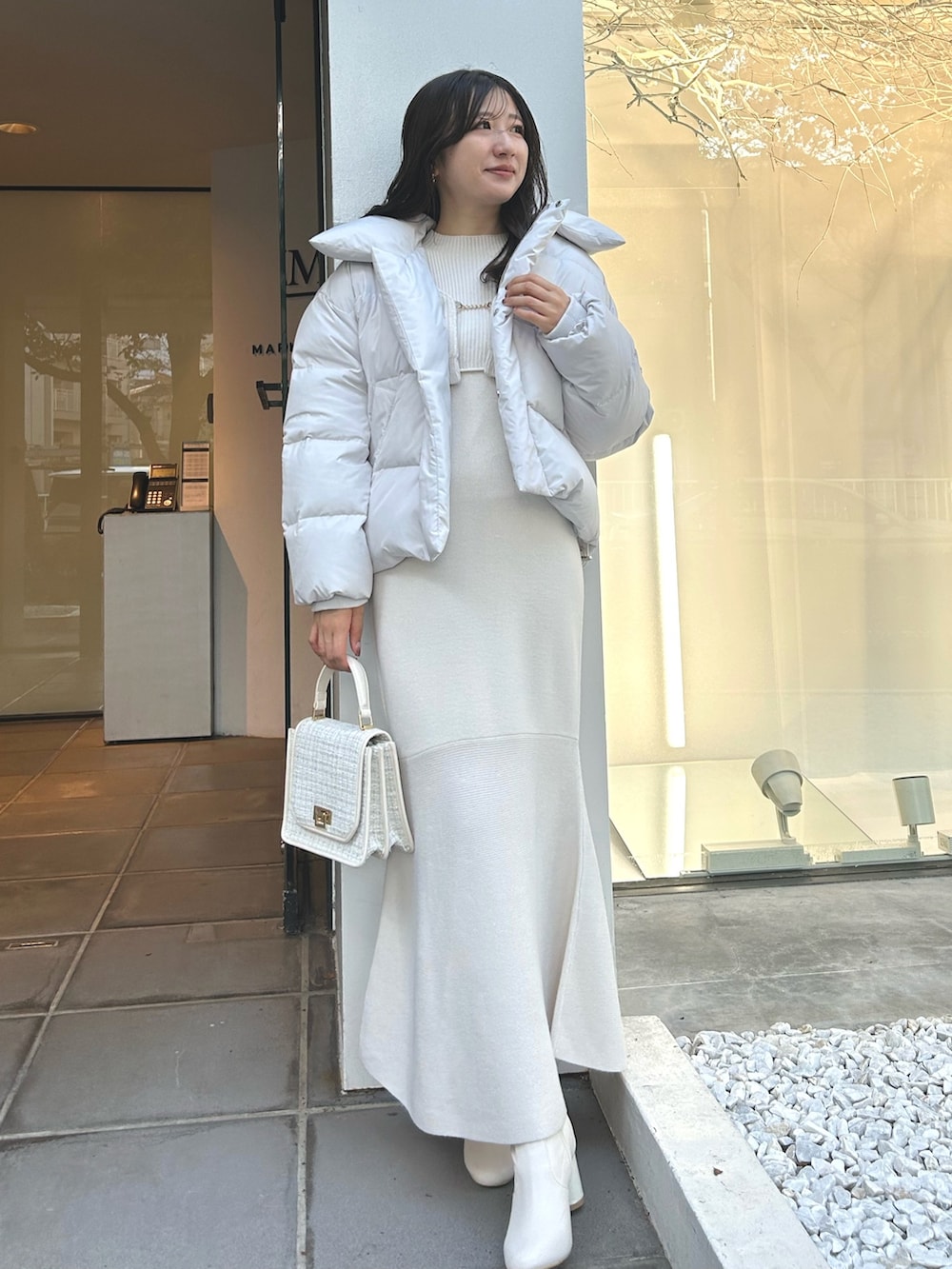ホワイト系のワンピース、ホワイト系のダウンジャケット/コート、ホワイト系のショルダーバッグを着用したレディースの秋コーディネートの9枚目の写真