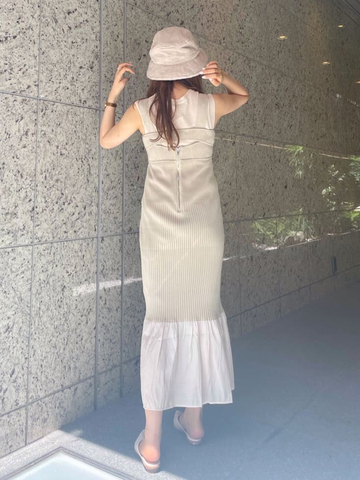 グリーン系のワンピース、ホワイト系のサンダル、ベージュ系のニット/セーターを着用したレディースの夏コーディネートの3枚目の写真