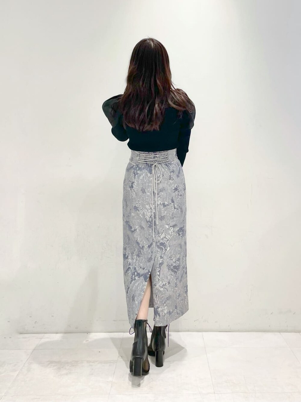 ブラック系のその他シューズ、ブルー系のスカート、ブラック系のニット/セーターを着用したレディースの冬コーディネートの3枚目の写真